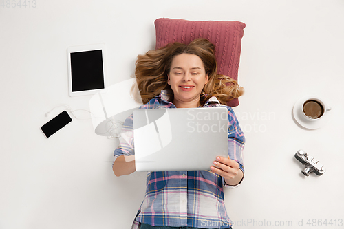 Image of Emotional caucasian woman using gadgets isolated on white studio background, technologies connecting people. Smiling
