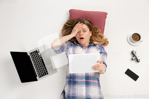 Image of Emotional caucasian woman using gadgets isolated on white studio background, technologies connecting people. Online shopping, selfie, gaming
