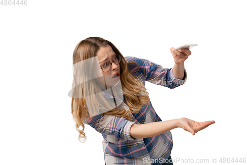 Image of Emotional caucasian woman using smartphone isolated on white studio background, technologies. Spilled coffee