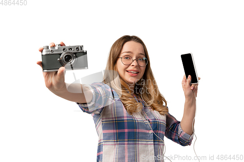 Image of Emotional caucasian woman using gadgets on white studio background, technologies. Shows camera and smartphone