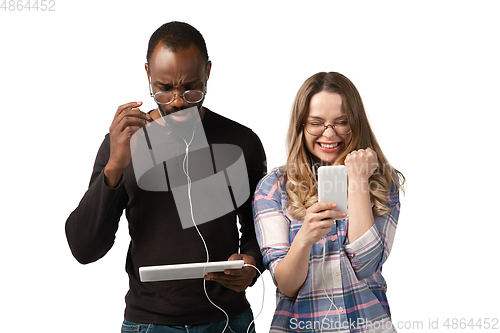 Image of Emotional man and woman using gadgets on white studio background, technologies connecting people. Gaming, shopping, online meeting