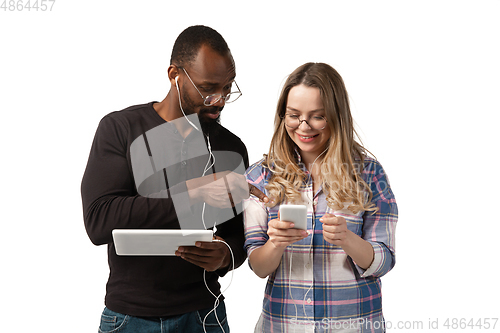 Image of Emotional man and woman using gadgets on white studio background, technologies connecting people. Gaming, shopping, online meeting