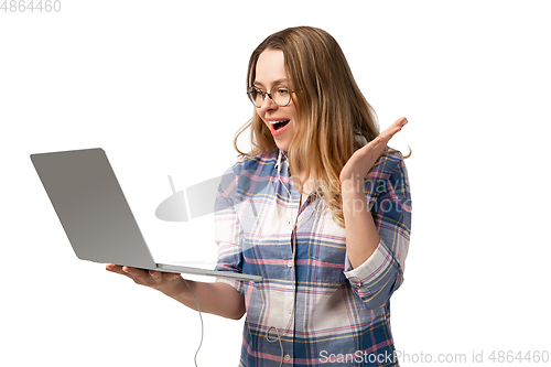 Image of Emotional caucasian woman using laptop on white studio background, technologies. Crazy happy