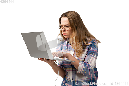 Image of Emotional caucasian woman using laptop on white studio background, technologies. Focused working