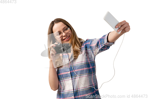 Image of Emotional caucasian woman using smartphone isolated on white studio background, technologies. Taking selfie with camera