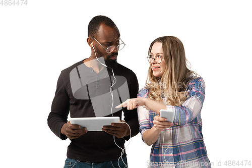 Image of Emotional man and woman using gadgets on white studio background, technologies connecting people. Gaming, shopping, online meeting
