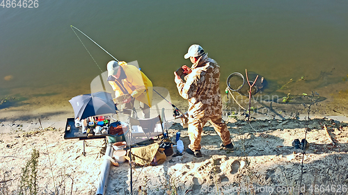 Image of Men take pictures of caught bream. Fishing on river. Male hobby. Recreation