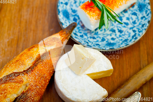 Image of French cheese and fresh  baguette on a wood cutter