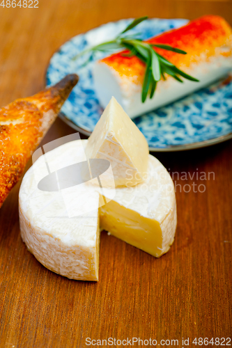 Image of French cheese and fresh  baguette on a wood cutter