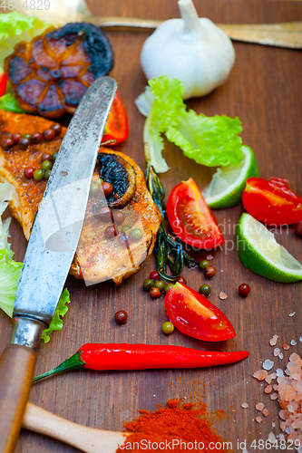 Image of wood fired hoven cooked chicken breast on wood board