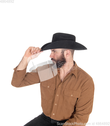 Image of Handsome man in brown shirt and black cowboy hat