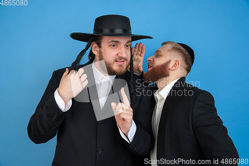 Image of Portrait of a young orthodox jewish men isolated on blue studio background, meeting the Passover