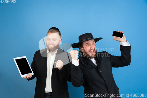 Image of Portrait of a young orthodox jewish men isolated on blue studio background, meeting the Passover, winners