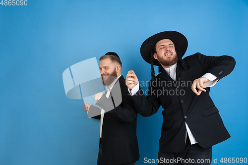 Image of Portrait of a young orthodox jewish men isolated on blue studio background, meeting the Passover