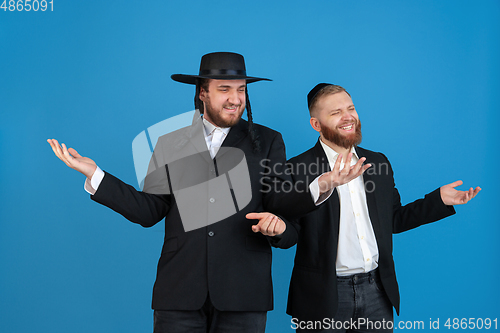 Image of Portrait of a young orthodox jewish men isolated on blue studio background, meeting the Passover