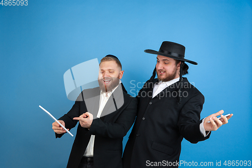 Image of Portrait of a young orthodox jewish men isolated on blue studio background, meeting the Passover