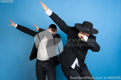 Image of Portrait of a young orthodox jewish men isolated on blue studio background, meeting the Passover, dab