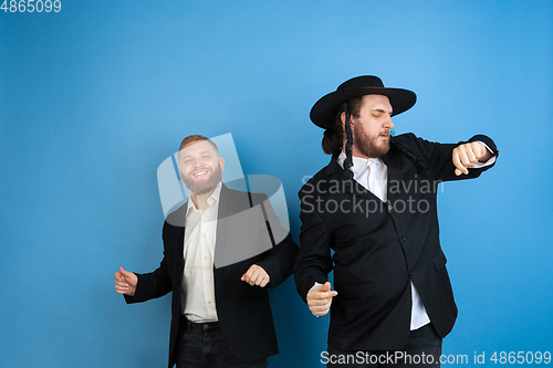 Image of Portrait of a young orthodox jewish men isolated on blue studio background, meeting the Passover