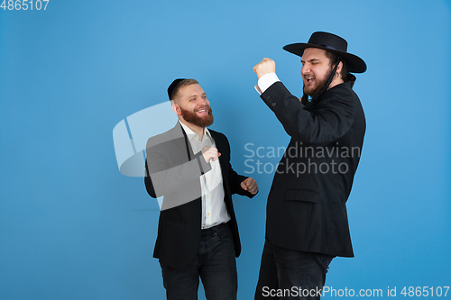 Image of Portrait of a young orthodox jewish men isolated on blue studio background, meeting the Passover