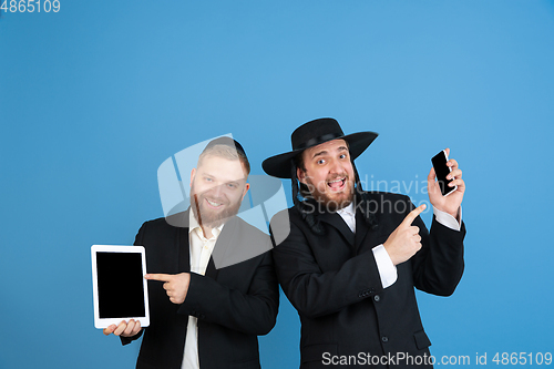 Image of Portrait of a young orthodox jewish men isolated on blue studio background, meeting the Passover, winners