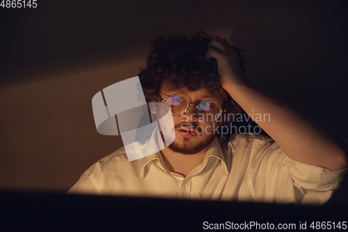 Image of Man working in office alone during coronavirus or COVID-19 quarantine, staying to late night