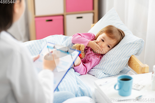 Image of doctor and ill coughing little girl in bed at home
