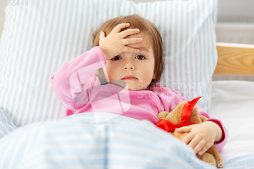 Image of sick little girl lying in bed at home