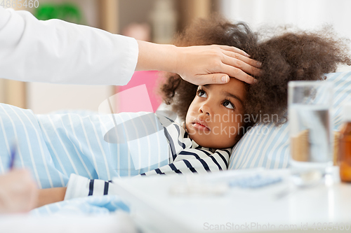 Image of doctor with clipboard and sick girl in bed at home