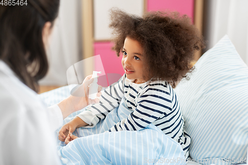 Image of doctor with medicine treats sick girl at home