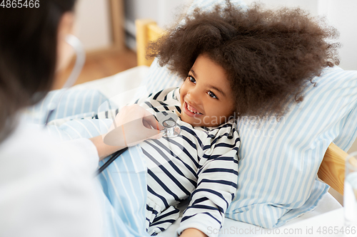 Image of doctor with stethoscope and sick girl in bed