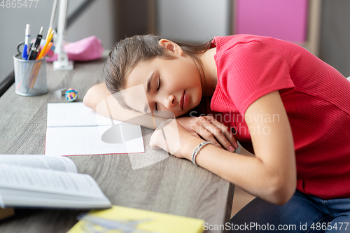 Image of tired student girl sleeping on table at home