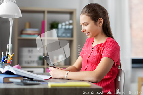 Image of girl with smartphone distracting from homework