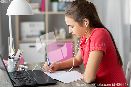 Image of student girl in earphones learning at home
