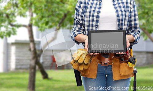 Image of woman builder with working tools showing tablet pc