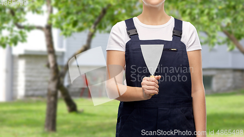 Image of close up of female builder with putty knife