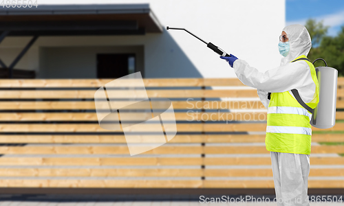 Image of sanitation worker in hazmat with pressure washer