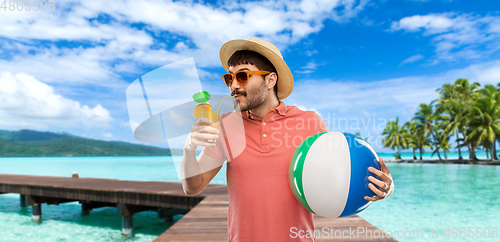 Image of happy man in straw hat with juice on beach