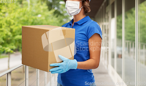 Image of delivery woman in face mask holding parcel box