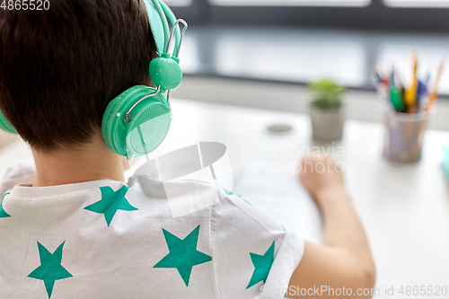 Image of boy in headphones with textbook learning at home