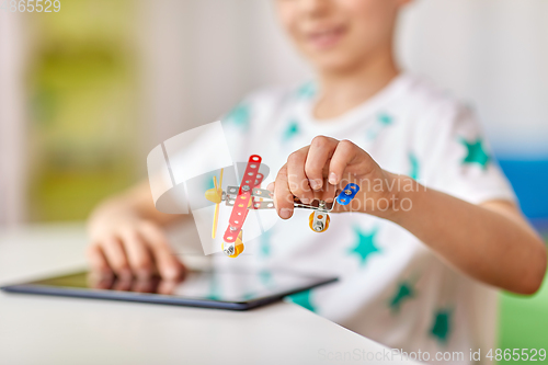 Image of happy little boy playing with airplane toy at home
