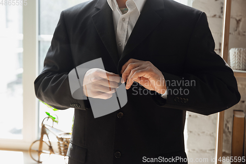 Image of Close up of caucasian male hands, wearing classic black jacket