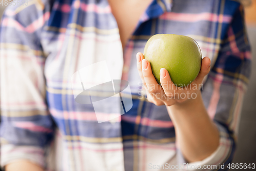 Image of Close up of female hand holding green apple, healthy food, fruits