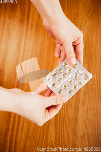 Image of Coronavirus. Novel coronavirus 2019-nCoV , COVID-29, hands of a woman holding pack of pills