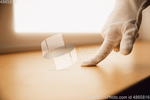 Image of Coronavirus. Novel coronavirus 2019-nCoV , COVID-29, hands of a woman in gloves checking the surface