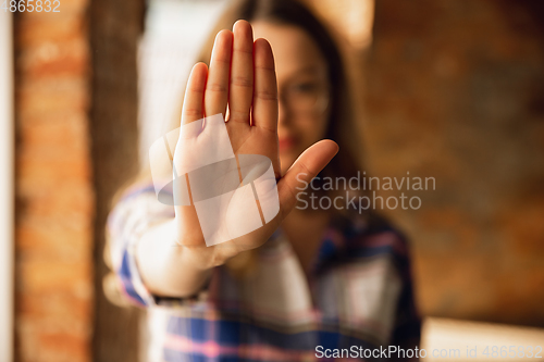 Image of Close up view of young woman making stop gesture with her hand. Cropped isolated portrait