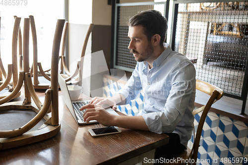 Image of Public institutions closed due to COVID-19 or Coronavirus outbreak lockdown, stressed owner of small business alone in his cafe, looking for solution