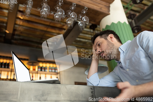 Image of Restaurant, cafe, bar closed due to COVID-19 or Coronavirus outbreak lockdown, stressed owner of small business trying to find solution