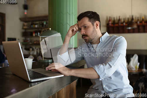 Image of Restaurant, cafe, bar closed due to COVID-19 or Coronavirus outbreak lockdown, stressed owner of small business trying to find solution