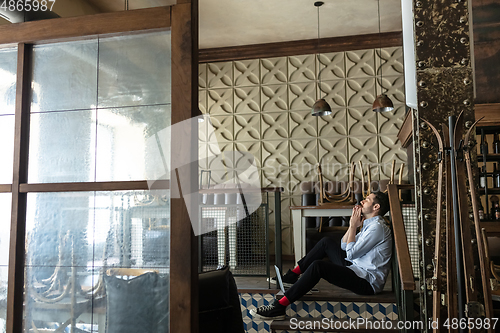 Image of Public institutions closed due to COVID-19 or Coronavirus outbreak lockdown, stressed owner of small business alone in his cafe, restaurant, bar