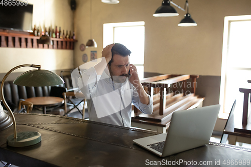 Image of Restaurant, cafe, bar closed due to COVID-19 or Coronavirus outbreak lockdown, stressed owner of small business trying to find solution